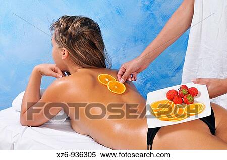 Stock Photography - Young woman receiving a beauty treatment with oranges. Fotosearch