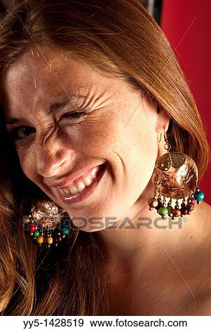 Young woman, red hair, big earrings, a gesture on his face, Gino. View Large Photo Image Stock Photo - Young woman, red hair, big earrings, a gesture on his face, Gino.. Fotosearch