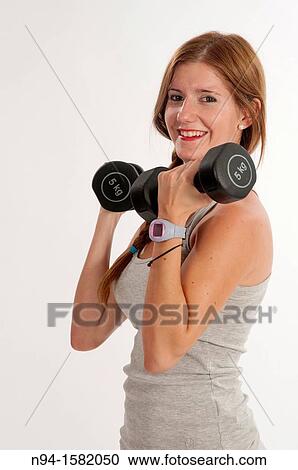 Young woman, redhead, exercising with weights in the gym to get fit View Large Photo Image Stock Image - Young woman, redhead, exercising with weights in the gym to get fit. Fotosearch
