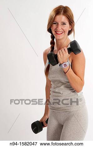 Young woman, redhead, exercising with weights in the gym to get fit View Large Photo Image Stock Photo - Young woman, redhead, exercising with weights in the gym to get fit. Fotosearch
