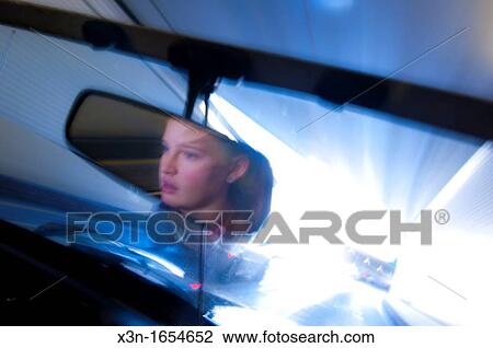 Young woman reflected in mirror driving through tunnel in sports car View Large Photo Image Stock Image - Young woman reflected in mirror driving through tunnel in sports car. Fotosearch