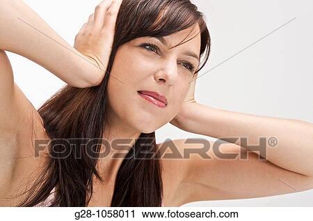 young woman refusing to hear and stopping noise by putting her fingers in her ears View Large Photo Image Stock Image - young woman refusing to hear and stopping noise by putting her fingers in her ears. Fotosearch
