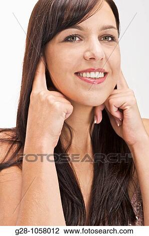 young woman refusing to hear and stopping noise by putting her fingers in her ears View Large Photo Image Stock Image - young woman refusing to hear and stopping noise by putting her fingers in her ears. Fotosearch