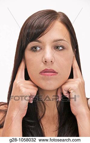 young woman refusing to hear and stopping noise by putting her fingers in her ears View Large Photo Image Stock Image - young woman refusing to hear and stopping noise by putting her fingers in her ears. Fotosearch