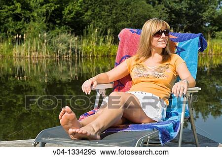 Stock Photography - Young woman relaxing at a lake, Germany, Europe. Fotosearch