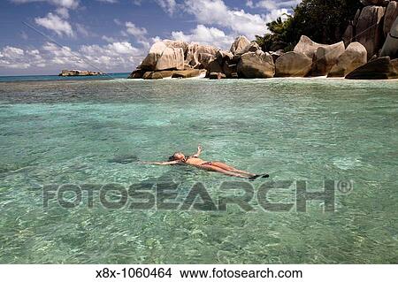 Young woman relaxing in the sea, Coco Island, Seychelles View Large Photo Image Picture - Young woman relaxing in the sea, Coco Island, Seychelles. Fotosearch