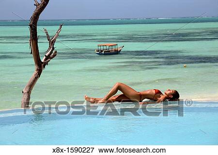 Young woman relaxing in the swimming pool at Pongwe Beach Hotel, Zanzibar, Tanzania View Large Photo Image Stock Photo - Young woman relaxing in the swimming pool at Pongwe Beach Hotel, Zanzibar, Tanzania. Fotosearch