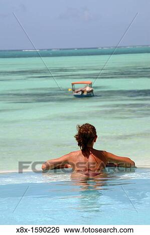 Young woman relaxing in the swimming pool at Pongwe Beach Hotel, Zanzibar, Tanzania View Large Photo Image Stock Photograph - Young woman relaxing in the swimming pool at Pongwe Beach Hotel, Zanzibar, Tanzania. Fotosearch