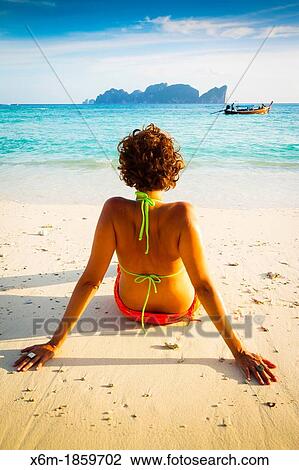 Stock Image - Young woman relaxing Long beach Phi Phi Don island Krabi province, Andaman Sea, Thailand. Fotosearch
