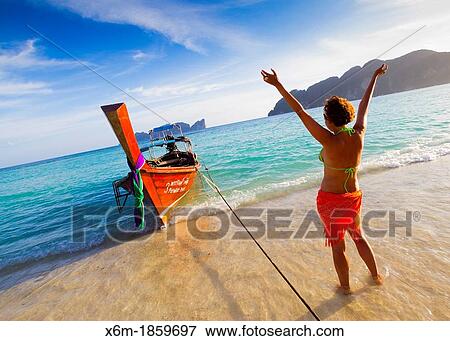 Stock Photo - Young woman relaxing Long beach Phi Phi Don island Krabi province, Andaman Sea, Thailand. Fotosearch