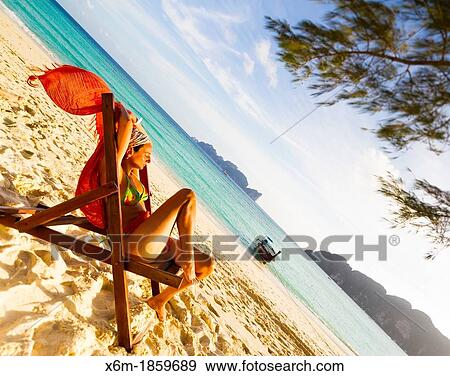 Young woman relaxing on a deckchair Long beach Phi Phi Don island Krabi province, Andaman Sea, Thailand View Large Photo Image Stock Photo - Young woman relaxing on a deckchair Long beach Phi Phi Don island Krabi province, Andaman Sea, Thailand. Fotosearch