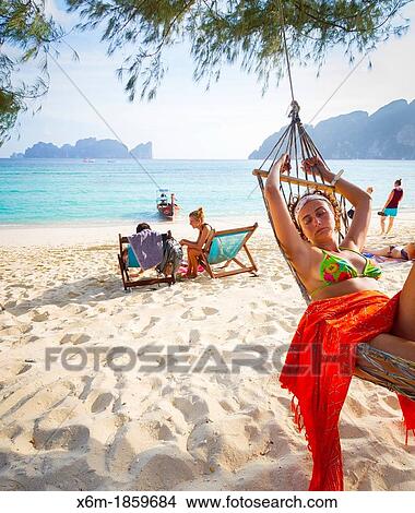 Picture - Young woman relaxing on a hammock Long beach Phi Phi Don island Krabi province, Andaman Sea, Thailand. Fotosearch