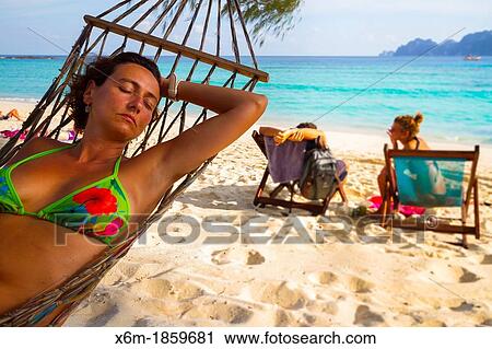 Stock Image - Young woman relaxing on a hammock Long beach Phi Phi Don island Krabi province, Andaman Sea, Thailand. Fotosearch
