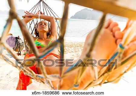 Stock Photograph - Young woman relaxing on a hammock Long beach Phi Phi Don island Krabi province, Andaman Sea, Thailand. Fotosearch