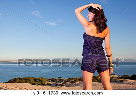 Stock Image - young woman relaxing with hands on his head. Fotosearch