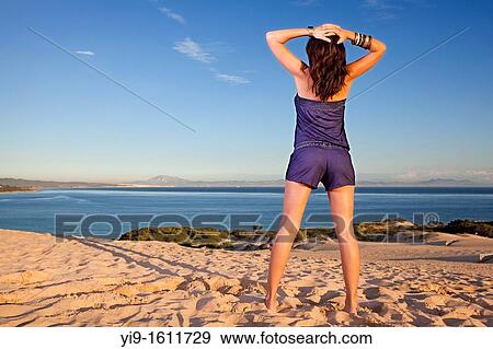 Stock Photo - young woman relaxing with hands on his head. Fotosearch