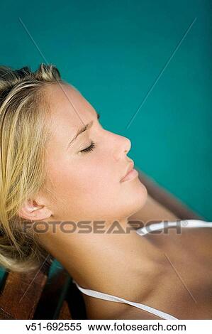 Young woman resting by a pool View Large Photo Image Stock Photography - Young woman resting by a pool. Fotosearch