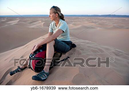 Young woman resting in the sand dunes of the Erg Chigaga Desert, Sahara, Morocco View Large Photo Image Stock Photo - Young woman resting in the sand dunes of the Erg Chigaga Desert, Sahara, Morocco. Fotosearch