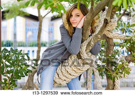 Young woman riding a tree branch View Large Photo Image Stock Photo - Young woman riding a tree branch. Fotosearch