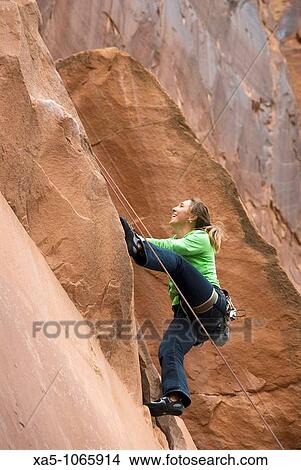 Picture - Young woman rock climbing off Utah Scenic Byway 279 near Moab, Utah, USA. Fotosearch