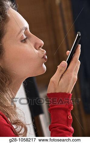 young woman? s hands holding a telephone and expressing her love or hope by kissing it View Large Photo Image Stock Photo - young woman? s hands holding a telephone and expressing her love or hope by kissing it. Fotosearch
