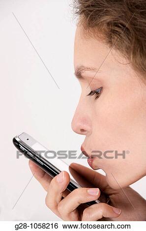 Stock Photograph - young woman? s hands holding a telephone and expressing her love or hope by kissing it. Fotosearch