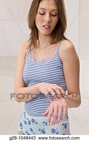 young woman scratching her arm because of an itching sensation View Large Photo Image Stock Image - young woman scratching her arm because of an itching sensation. Fotosearch