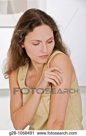 young woman scratching her arm because of an itching sensation View Large Photo Image Stock Image - young woman scratching her arm because of an itching sensation. Fotosearch