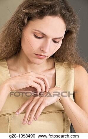 young woman scratching her hand because of an itching sensation View Large Photo Image Stock Image - young woman scratching her hand because of an itching sensation. Fotosearch
