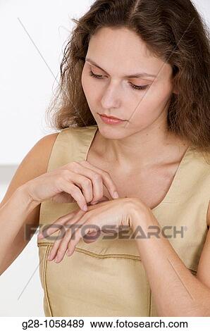 young woman scratching her hand because of an itching sensation View Large Photo Image Stock Photo - young woman scratching her hand because of an itching sensation. Fotosearch