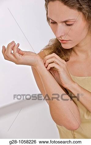 young woman scratching the inside of her wrist because of an itching sensation View Large Photo Image Stock Photograph - young woman scratching the inside of her wrist because of an itching sensation. Fotosearch