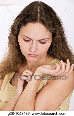 young woman scratching the inside of her wrist because of an itching sensation View Large Photo Image Stock Photograph - young woman scratching the inside of her wrist because of an itching sensation. Fotosearch