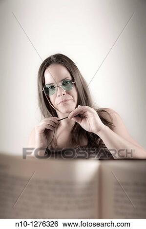 Young woman seen from behind a book View Large Photo Image Stock Photograph - Young woman seen from behind a book. Fotosearch
