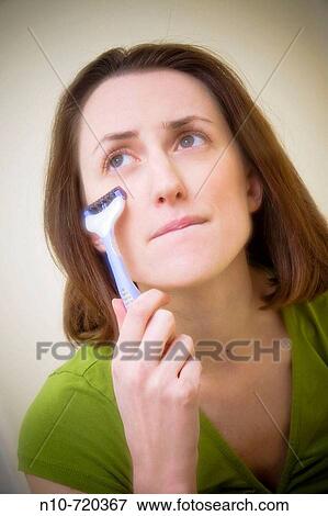 Young woman shaving her face. View Large Photo Image Stock Photo - Young woman shaving her face.. Fotosearch