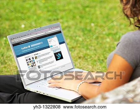 Young woman signing in on her Twitter page online on a laptop alone at the park View Large Photo Image Stock Photo - Young woman signing in on her Twitter page online on a laptop alone at the park. Fotosearch