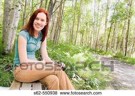 Young Woman Sits on Bench, Outdoors View Large Photo Image Stock Photo - Young Woman Sits on Bench, Outdoors. Fotosearch