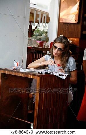 Stock Photo - Young woman sitting at cafe Delias in the city center, Vienna, Austria. Fotosearch