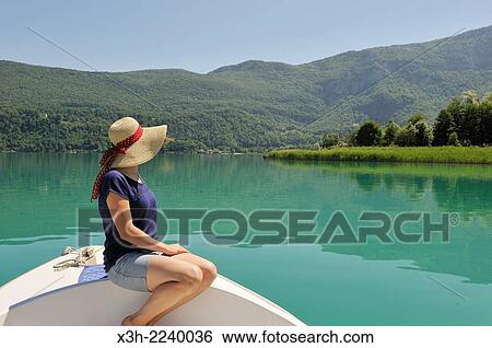 young woman sitting at the prow of a small boat powered with electric motor on the natural Lake of Aiguebelette, department of Savoie, Rhone-Alpes region, France, Europe. View Large Photo Image Stock Photograph - young woman sitting at the prow of a small boat powered with electric motor on the natural Lake of Aiguebelette, department of Savoie, Rhone-Alpes region, France, Europe.. Fotosearch