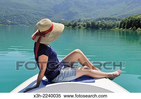 young woman sitting at the prow of a small boat powered with electric motor on the natural Lake of Aiguebelette, department of Savoie, Rhone-Alpes region, France, Europe. View Large Photo Image Stock Photography - young woman sitting at the prow of a small boat powered with electric motor on the natural Lake of Aiguebelette, department of Savoie, Rhone-Alpes region, France, Europe.. Fotosearch