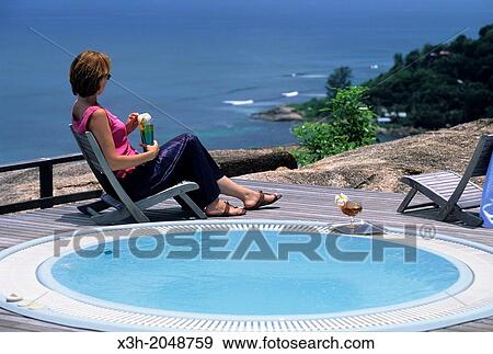 young woman sitting by a jacuzzi at the Le Chateau de Feuilles luxury hotel, Praslin island, Republic of Seychelles, Indian Ocean View Large Photo Image Stock Photo - young woman sitting by a jacuzzi at the Le Chateau de Feuilles luxury hotel, Praslin island, Republic of Seychelles, Indian Ocean. Fotosearch
