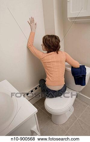 Young woman sitting in her bathroom. View Large Photo Image Stock Photo - Young woman sitting in her bathroom.. Fotosearch