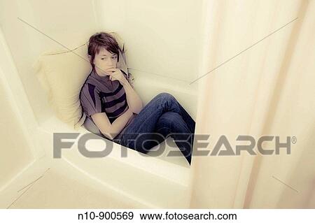 Young woman sitting in her bathtub. View Large Photo Image Stock Photo - Young woman sitting in her bathtub.. Fotosearch