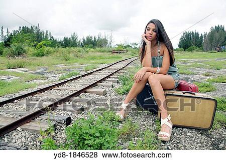 Young woman sitting next to the railroad tracks, Miami, Florida, USA View Large Photo Image Stock Photo - Young woman sitting next to the railroad tracks, Miami, Florida, USA. Fotosearch