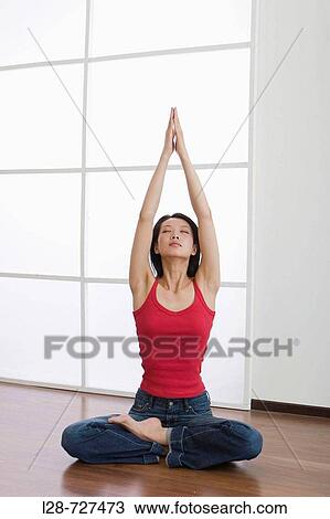 Young woman sitting on floor, hands in prayer position above head View Large Photo Image Stock Image - Young woman sitting on floor, hands in prayer position above head. Fotosearch