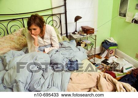 Young woman sitting on her bed. View Large Photo Image Stock Image - Young woman sitting on her bed.. Fotosearch