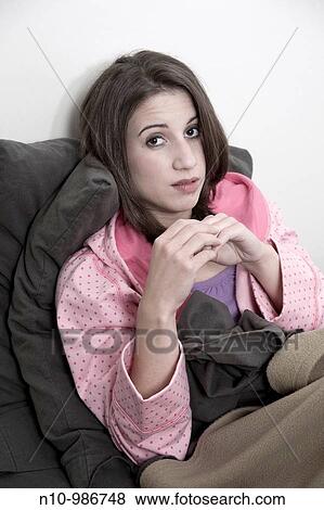 Stock Photo - Young woman sitting on her bed. Fotosearch