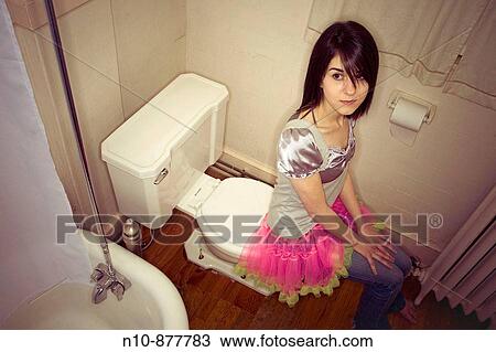 Young woman sitting on the edge of her toilet. Model and Property Released. View Large Photo Image Stock Image - Young woman sitting on the edge of her toilet. Model and Property Released.. Fotosearch