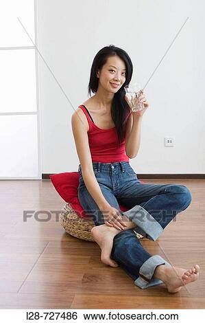 Young woman sitting on water, holding glass of water, smiling View Large Photo Image Stock Photograph - Young woman sitting on water, holding glass of water, smiling. Fotosearch