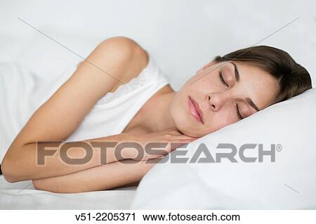 Young woman sleeping in bed View Large Photo Image Stock Image - Young woman sleeping in bed. Fotosearch