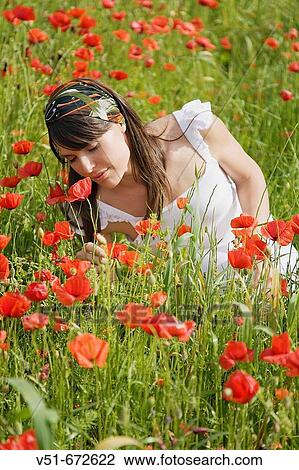 Young woman smelling flowers in the countryside View Large Photo Image Stock Image - Young woman smelling flowers in the countryside. Fotosearch